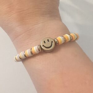 645 Yellow and White Heishi Beaded Stretch Bracelet‎ with Gold Smiley Face